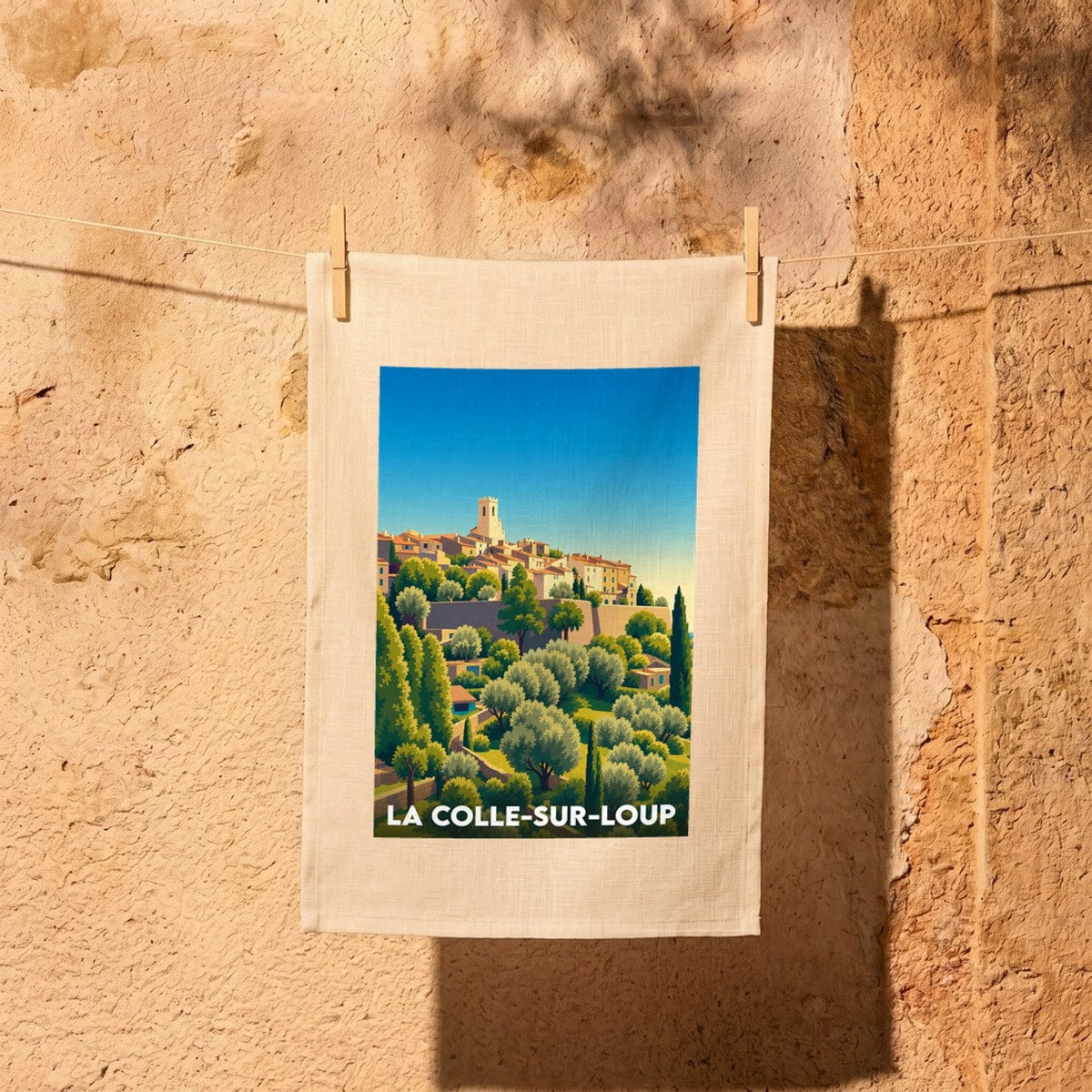 Torchon souvenir de la ville de La Colle-sur-Loup avec une illustration stylisée du village perché.