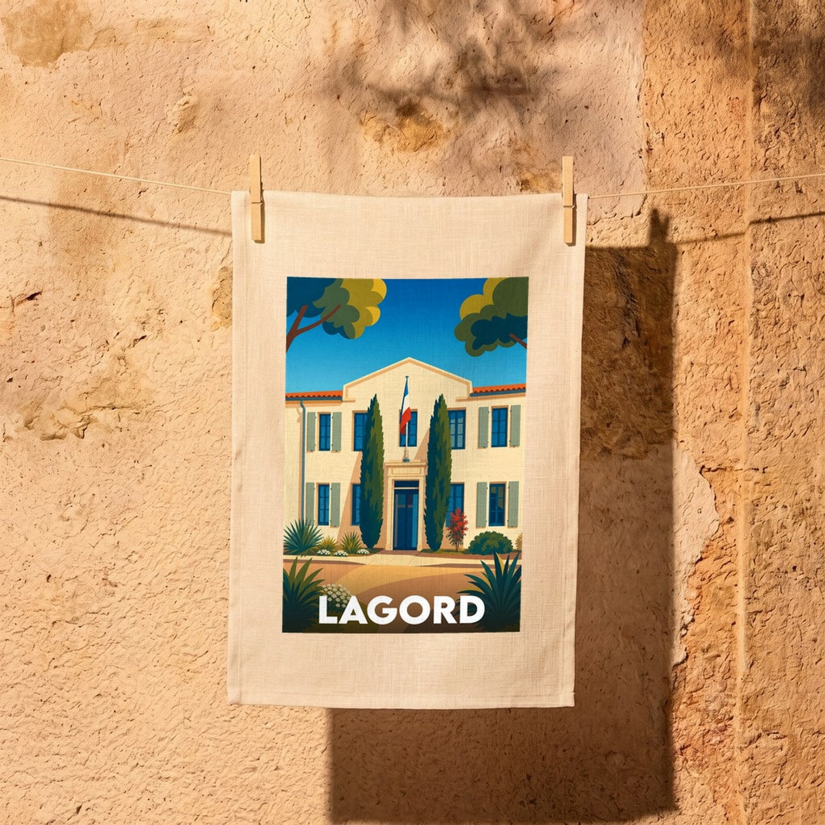 Torchon souvenir de la ville de Lagord avec une illustration stylisée de sa mairie sous un ciel bleu.