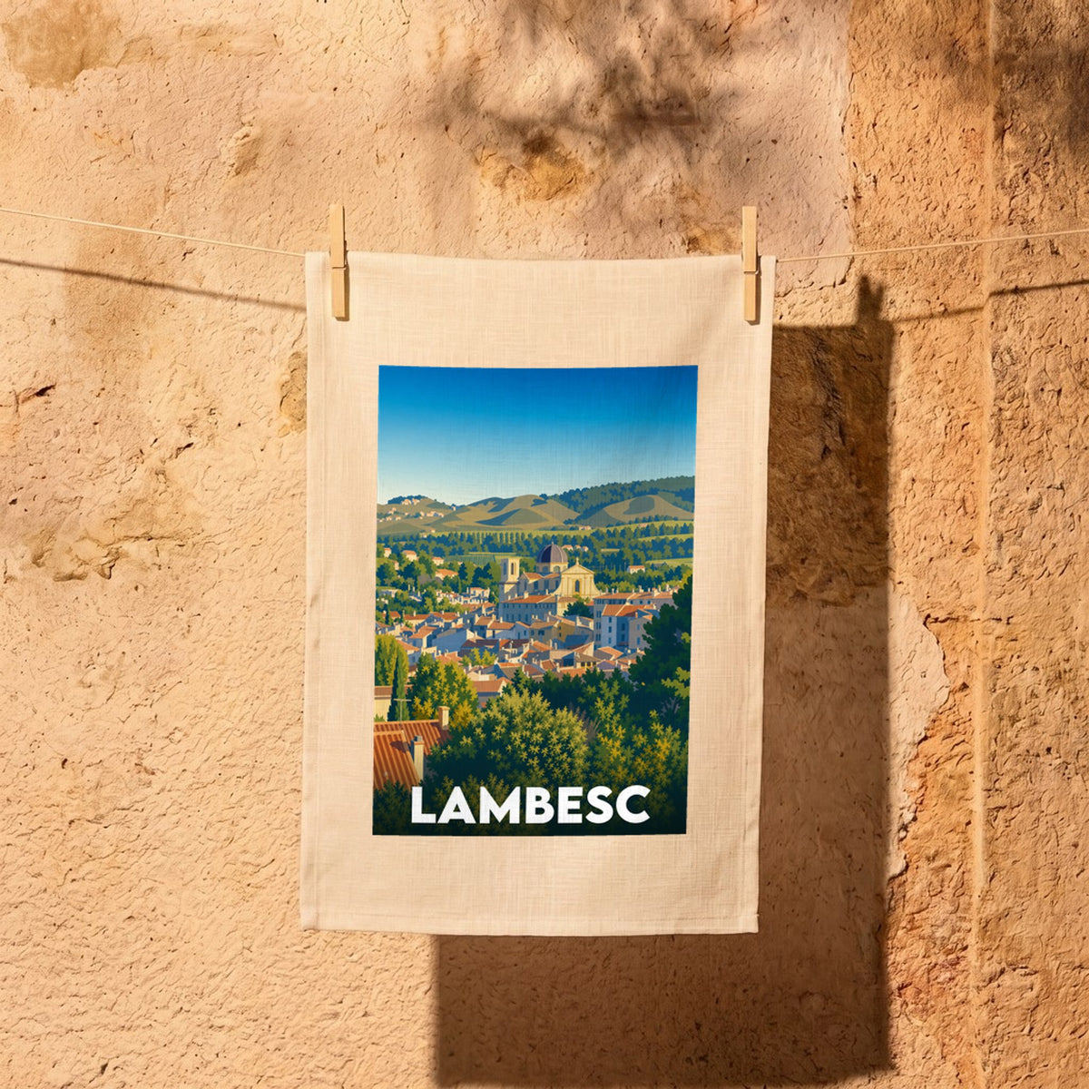 Torchon souvenir de la ville de Lambesc avec une illustration stylisée du village provençal.