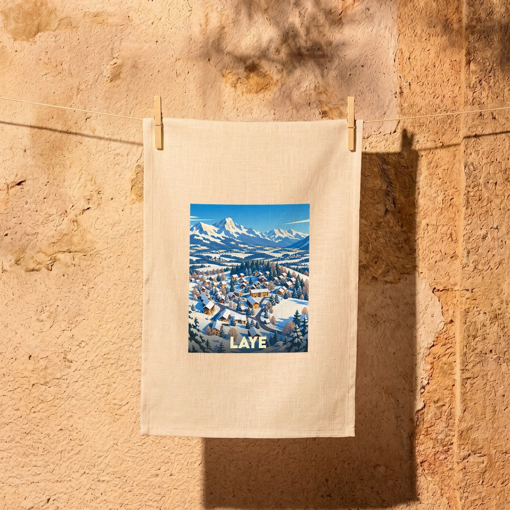 Torchon souvenir de la ville de Laye illustré d'un paysage de montagne enneigé.