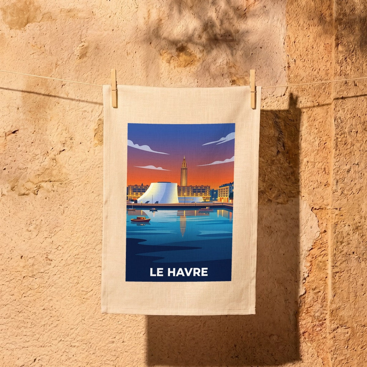 Torchon souvenir de la ville de Le Havre avec une illustration stylisée de son port au coucher du soleil.