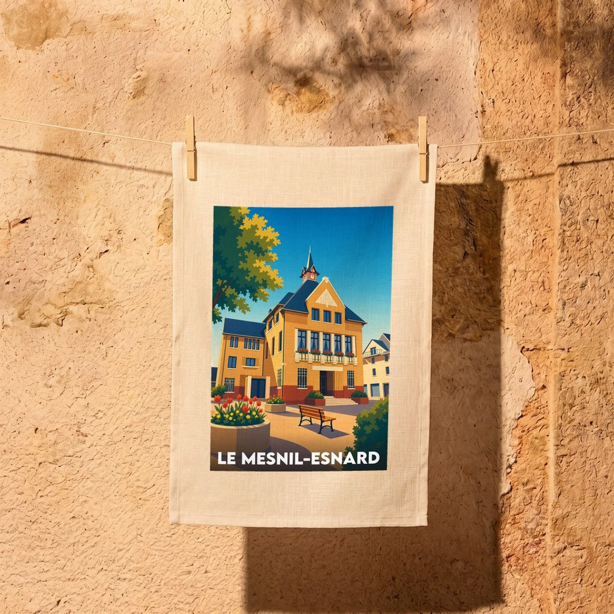 Torchon souvenir de la ville de Le Mesnil-Esnard avec une illustration stylisée de sa mairie.