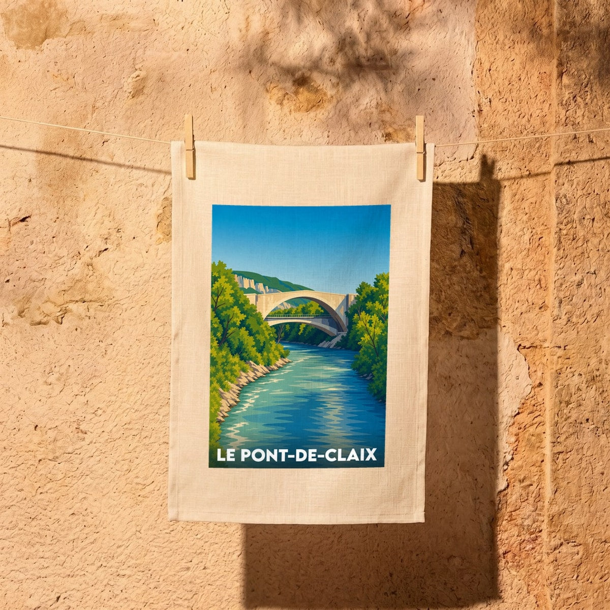 Torchon souvenir de la ville de Le Pont-de-Claix avec une illustration stylisée d'un pont en pierre surplombant une rivière.