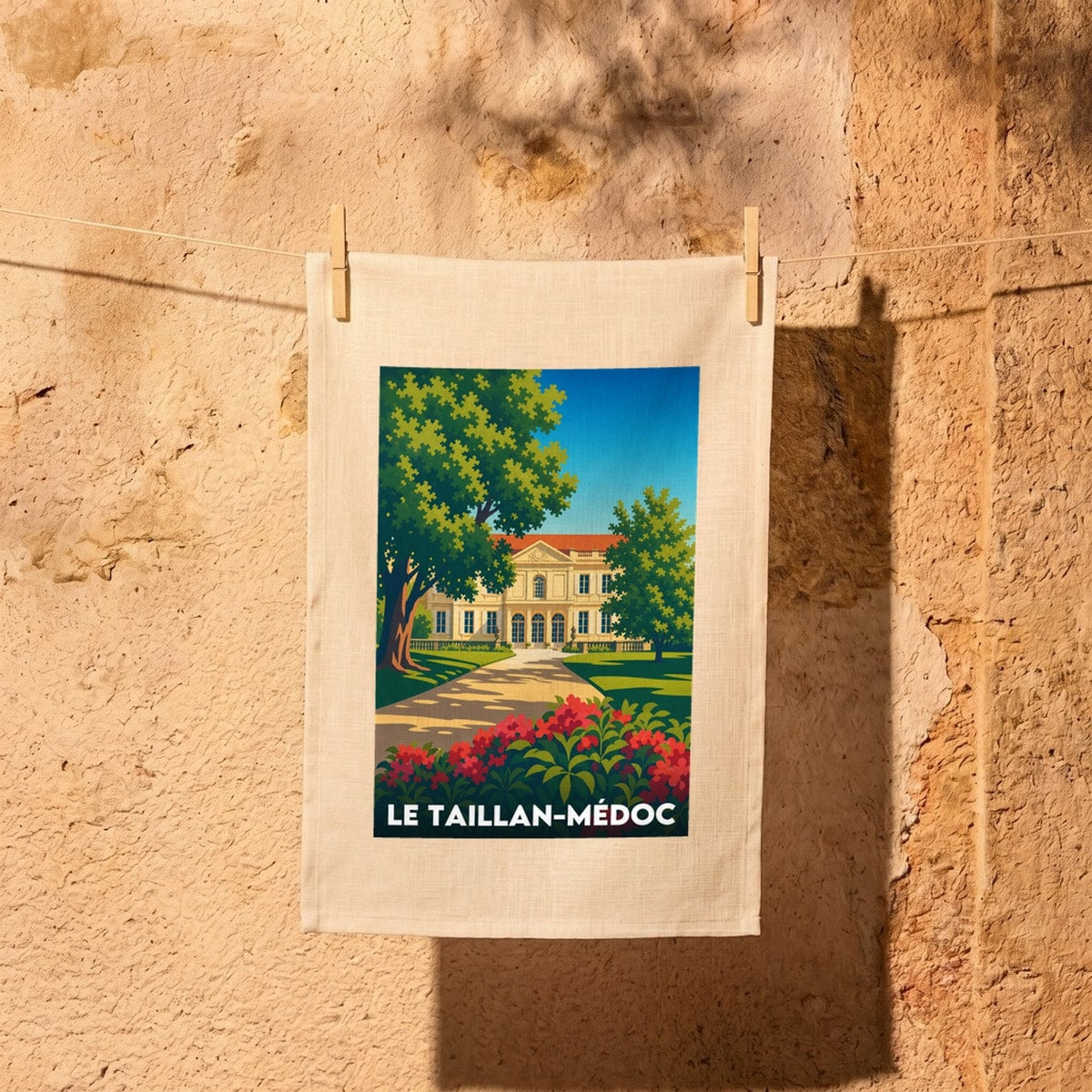 Torchon souvenir de la ville de Le Taillan-Médoc avec une illustration stylisée d'un château.