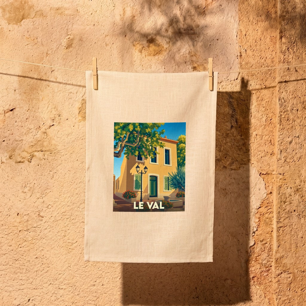 Torchon souvenir de la ville de Le Val illustré d'une scène de village provençal ensoleillé.