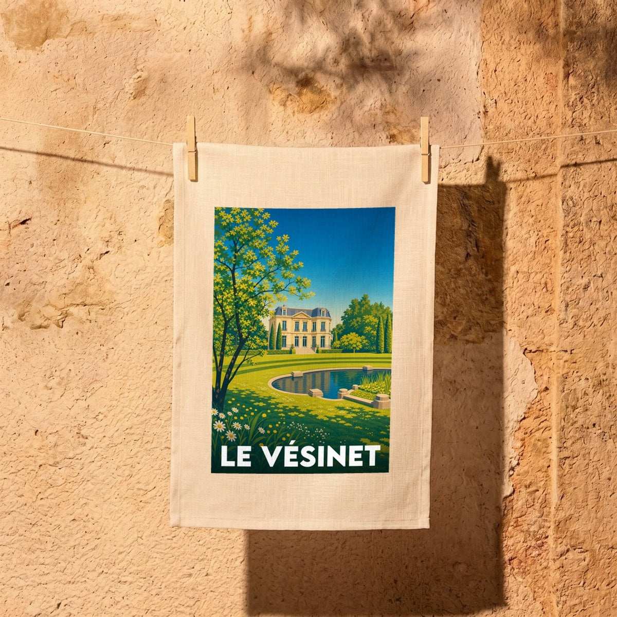 Torchon souvenir de la ville de Le Vésinet avec une illustration stylisée d'un manoir et d'un parc.