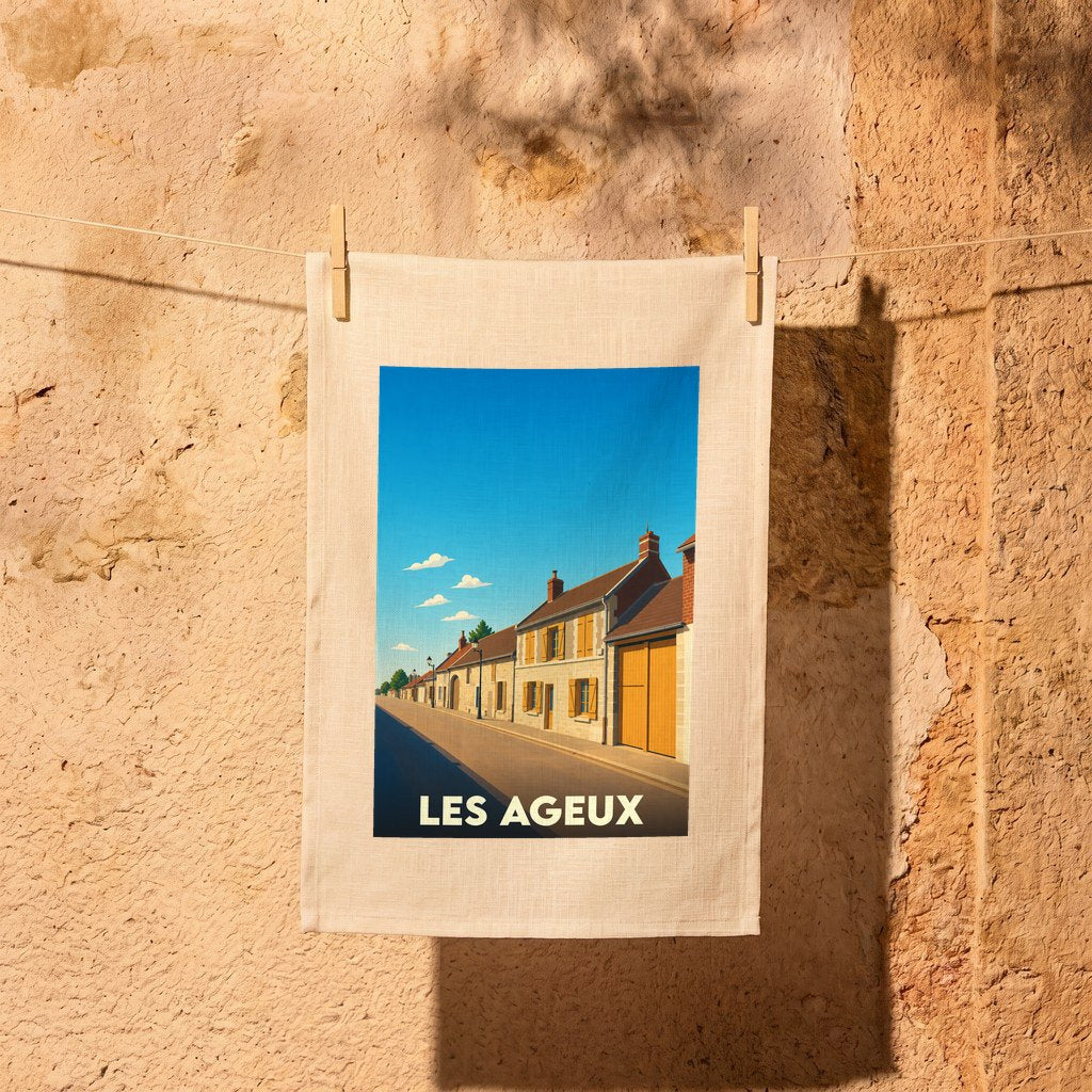 Torchon souvenir de la ville de Les Ageux avec une illustration stylisée d'une rue ensoleillée.