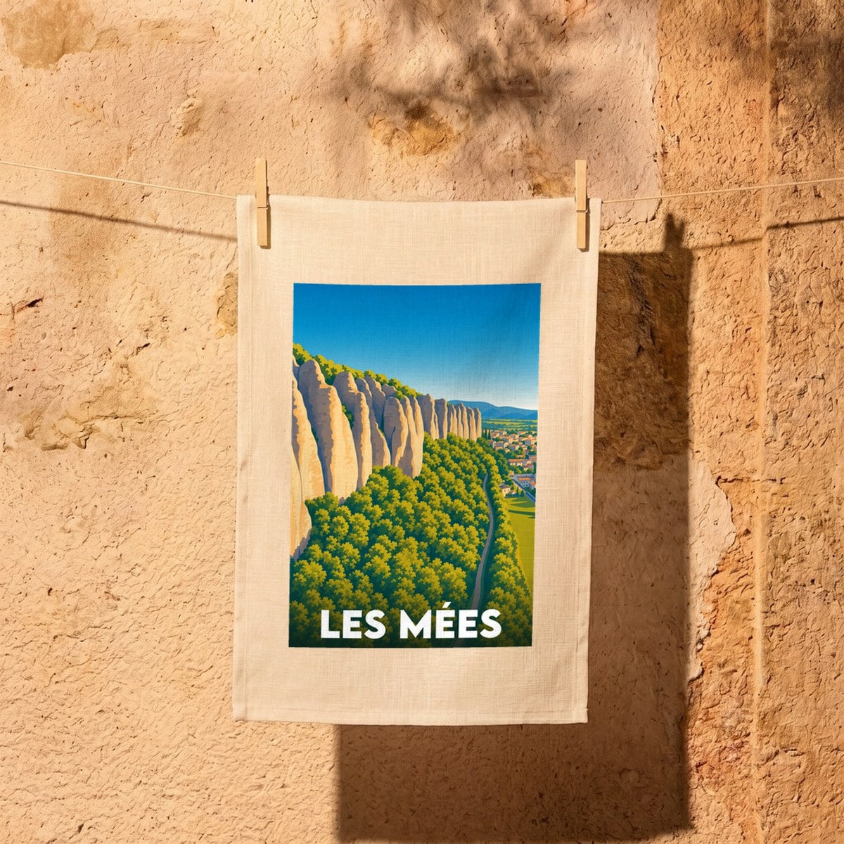 Torchon souvenir de la ville de Les Mées avec une illustration stylisée des falaises des Pénitents.