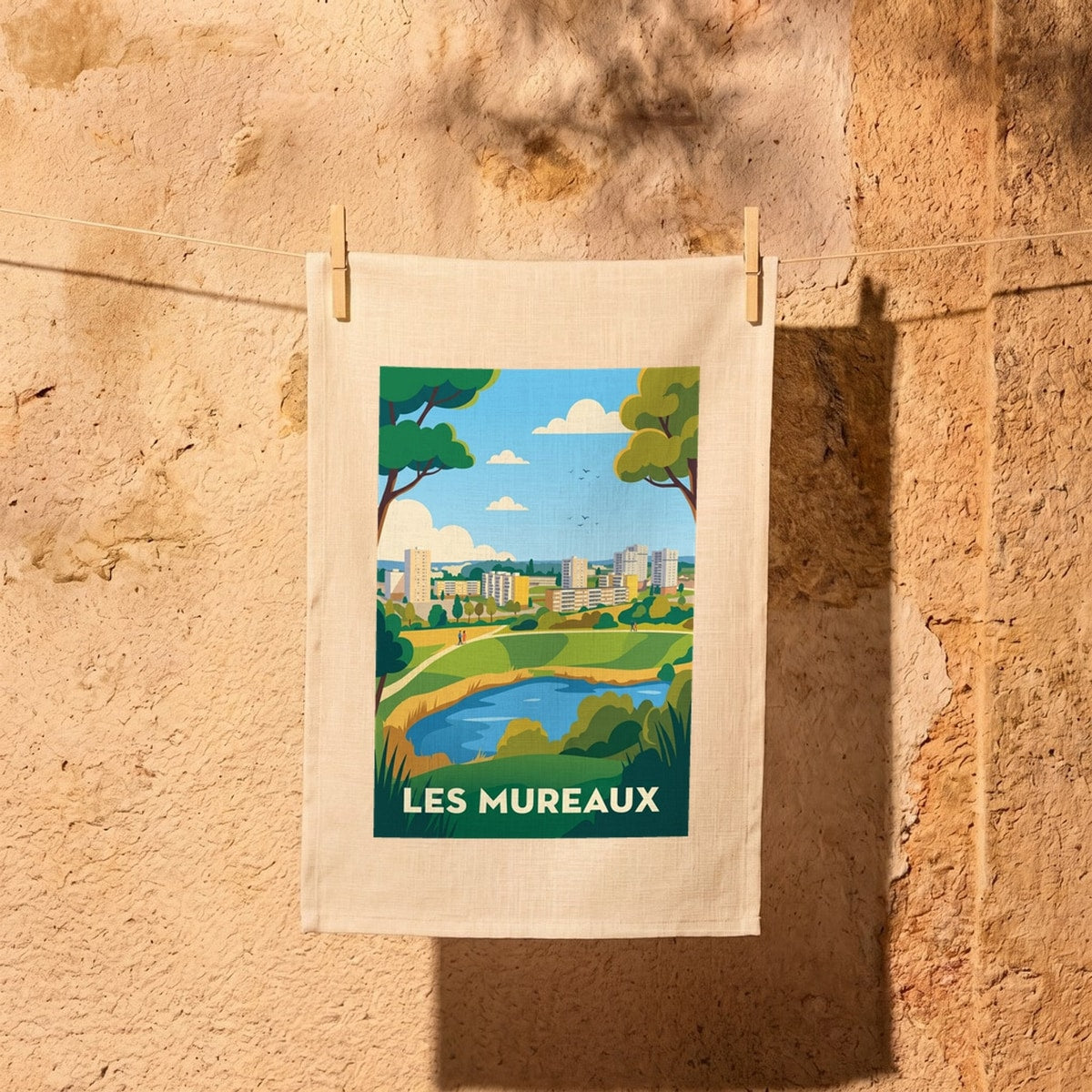 Torchon souvenir de la ville des Mureaux avec une illustration stylisée d'un parc et de bâtiments.