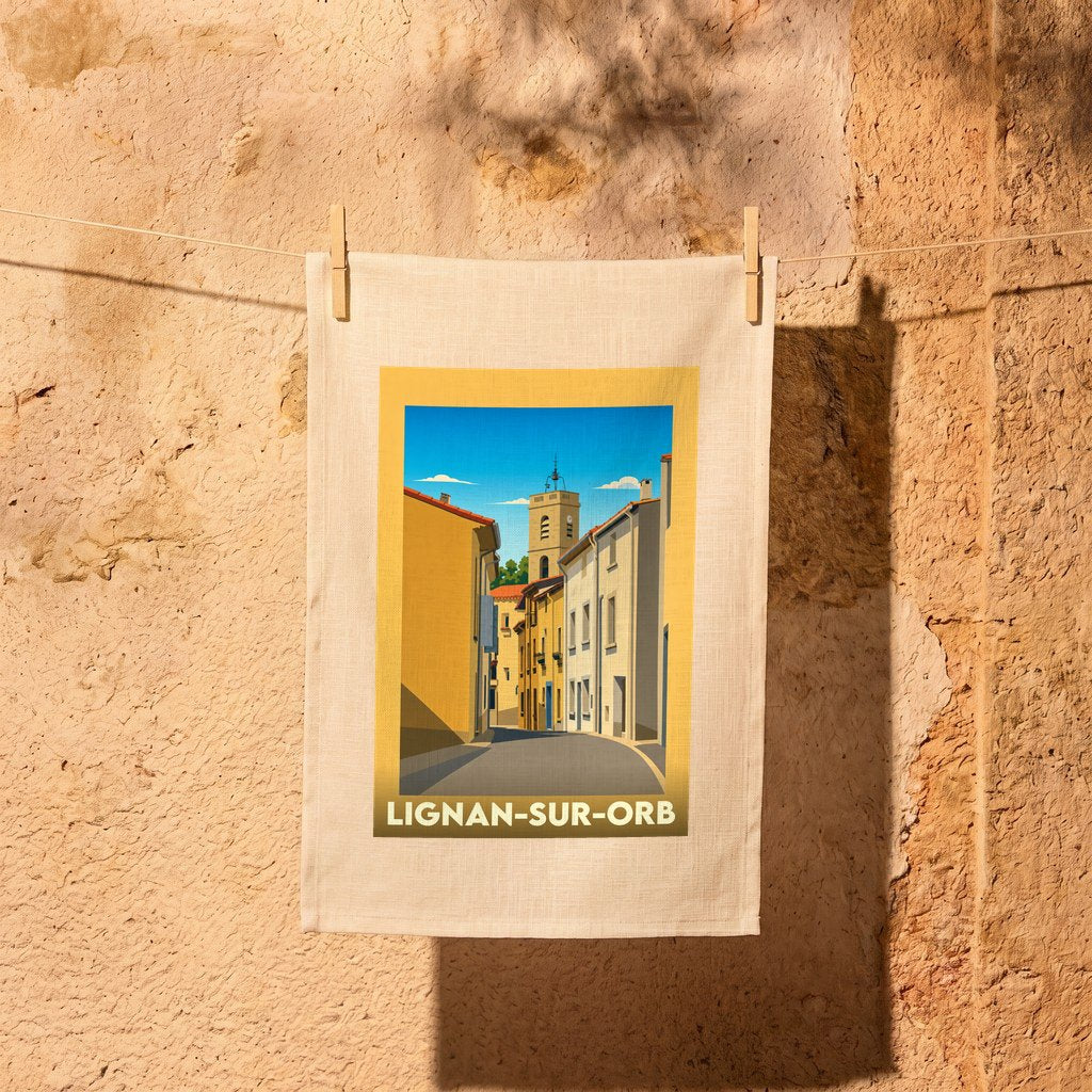 Torchon souvenir de la ville de Lignan-sur-Orb illustré par une vue stylisée d'une rue pittoresque.