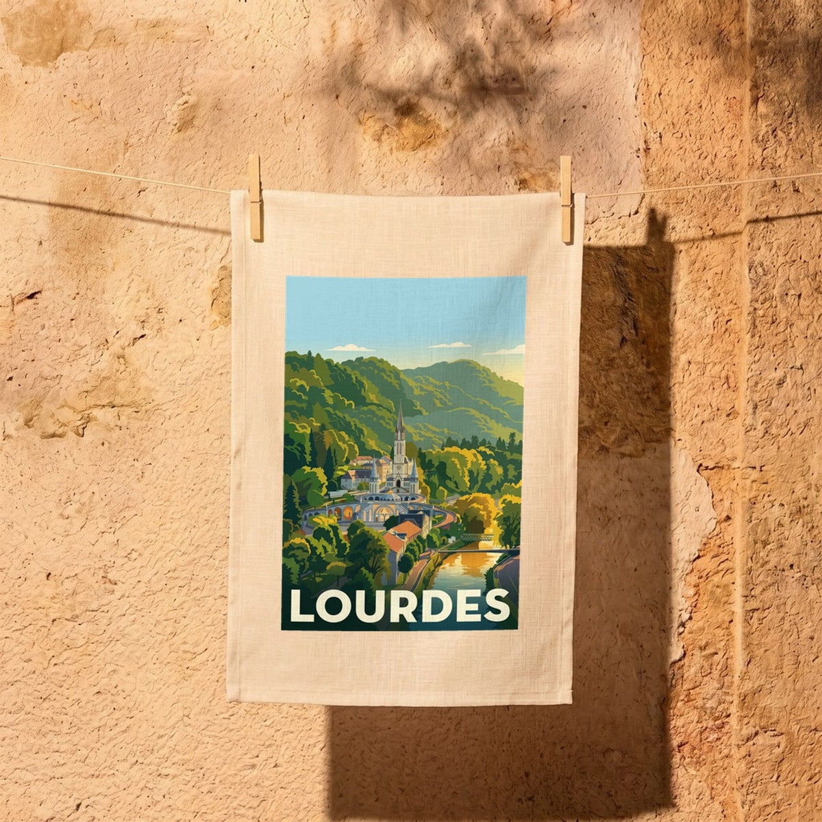 Torchon souvenir de la ville de Lourdes avec une illustration stylisée.