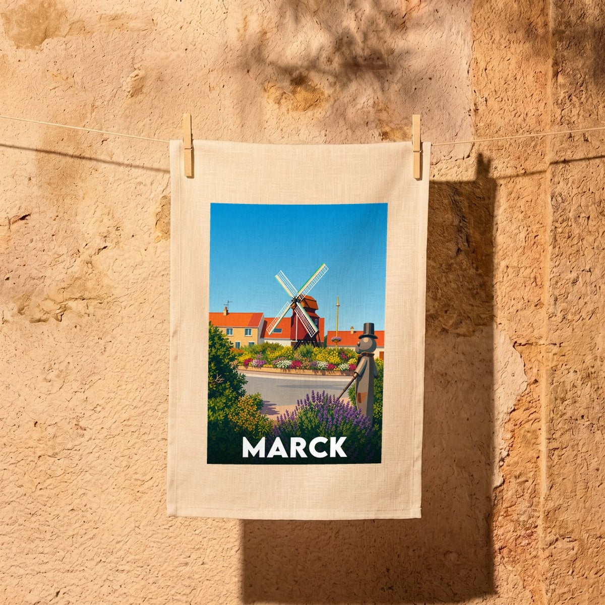 Torchon souvenir de la ville de Marck avec une illustration stylisée d'un moulin et d'un personnage.