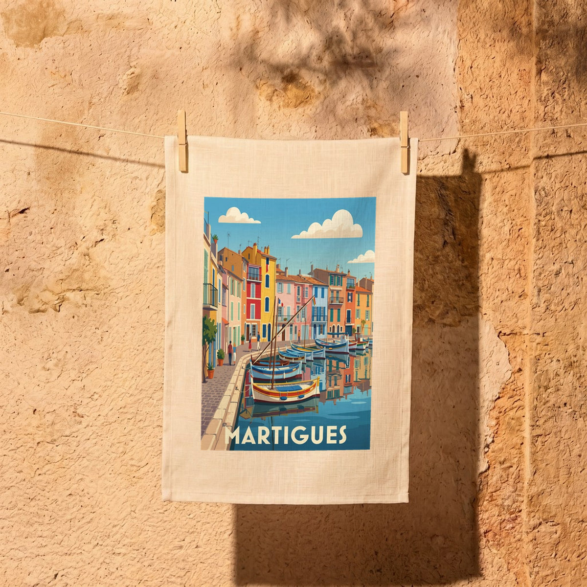 Torchon souvenir de la ville de Martigues avec une illustration stylisée de son port coloré.