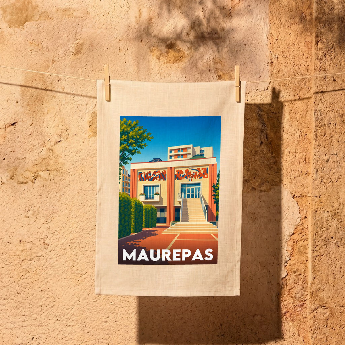 Torchon souvenir de la ville de Maurepas avec une illustration architecturale stylisée.