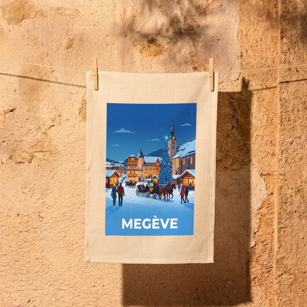 Torchon souvenir de la ville de Megève avec une illustration stylisée d'un paysage hivernal enneigé.