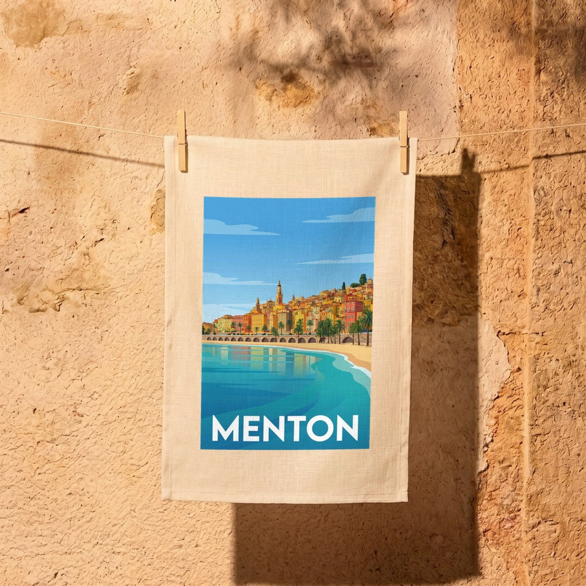 Torchon souvenir de la ville de Menton avec une illustration stylisée de son front de mer coloré.