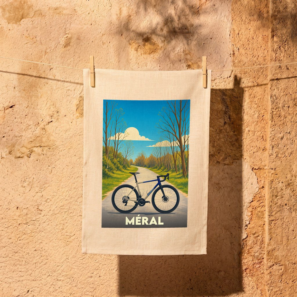 Torchon souvenir de la ville de Méral illustré d'un vélo sur une route de campagne.