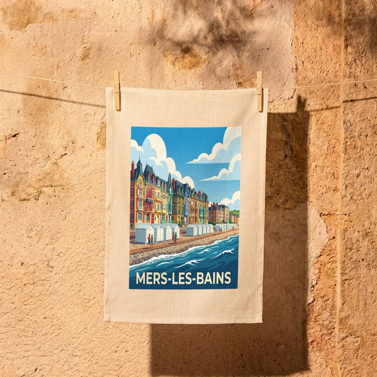 Torchon souvenir de la ville de Mers-les-Bains avec une illustration stylisée de son front de mer et de ses villas colorées.