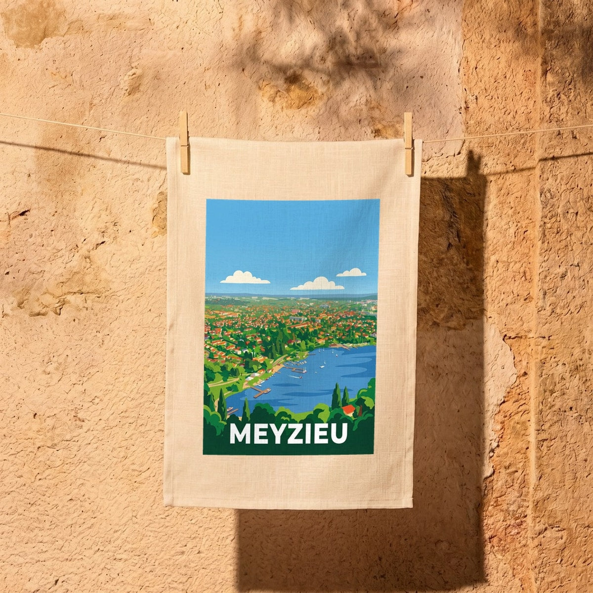 Torchon souvenir de la ville de Meyzieu avec une illustration stylisée de son paysage et du lac.