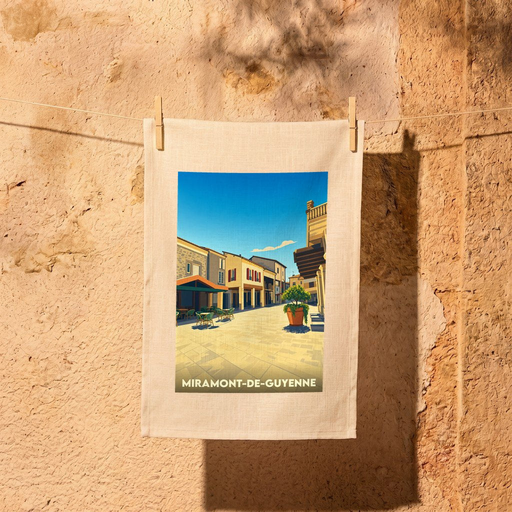 Torchon souvenir de la ville de Miramont-de-Guyenne avec une illustration stylisée d'une place ensoleillée.