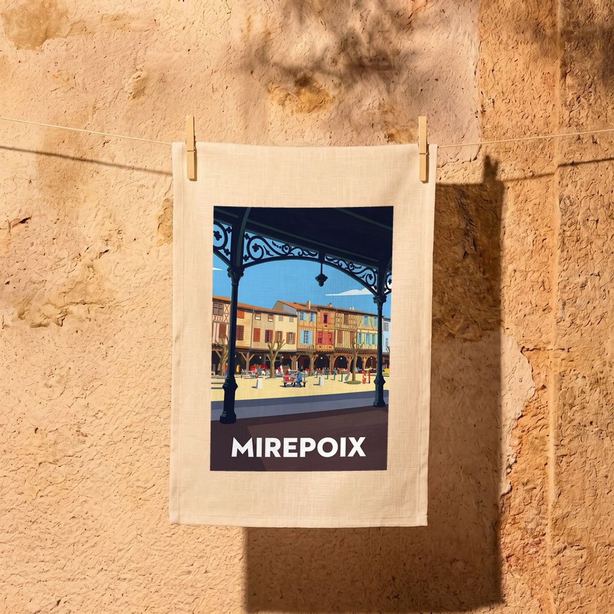 Torchon souvenir de la ville de Mirepoix avec une illustration stylisée de sa place médiévale.