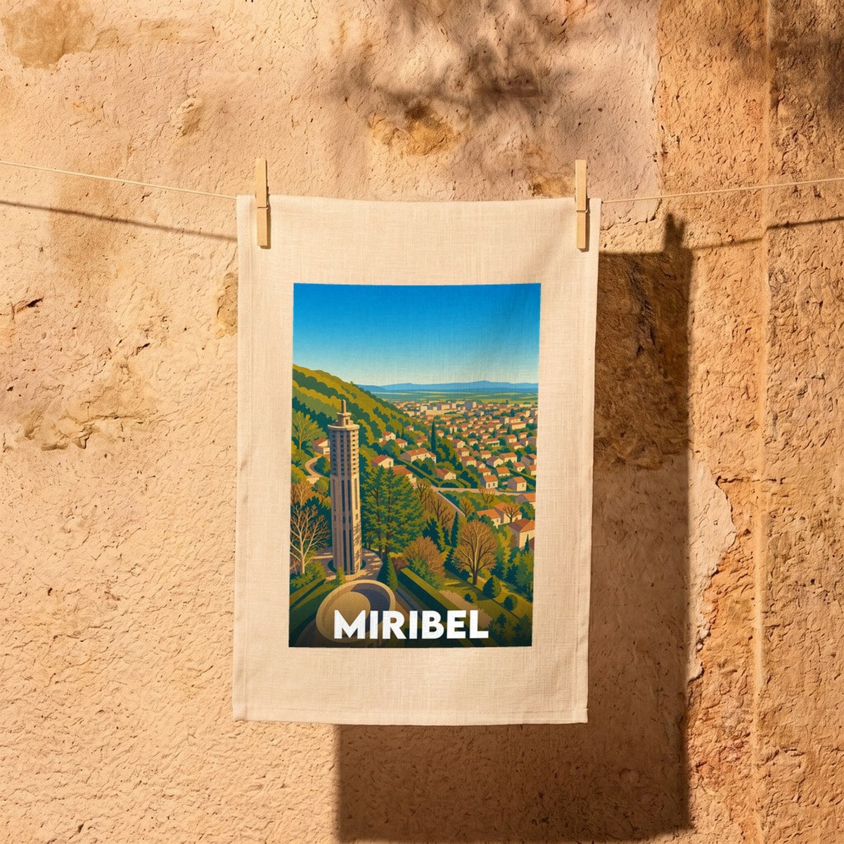 Torchon souvenir de la ville de Miribel orné d'une illustration stylisée représentant sa tour emblématique et son panorama.