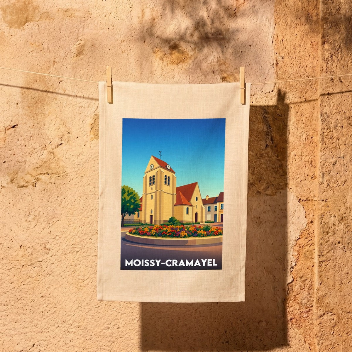 Torchon souvenir de la ville de Moissy-Cramayel avec une illustration colorée et stylisée de son église.
