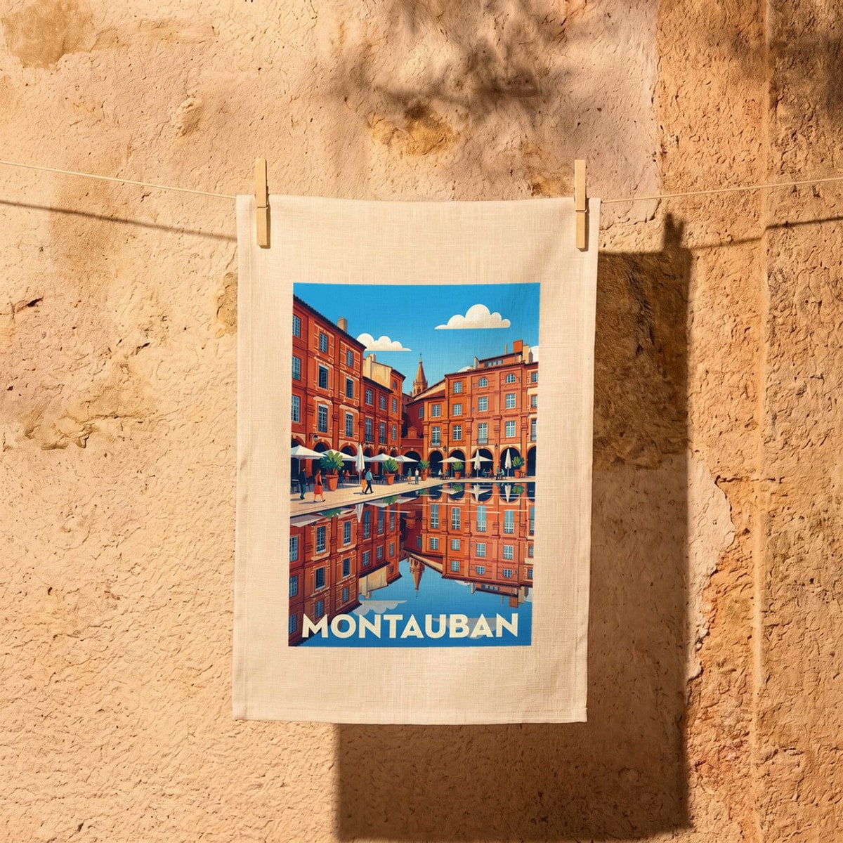 Torchon souvenir de la ville de Montauban avec une illustration stylisée de ses célèbres arcades en briques rouges.