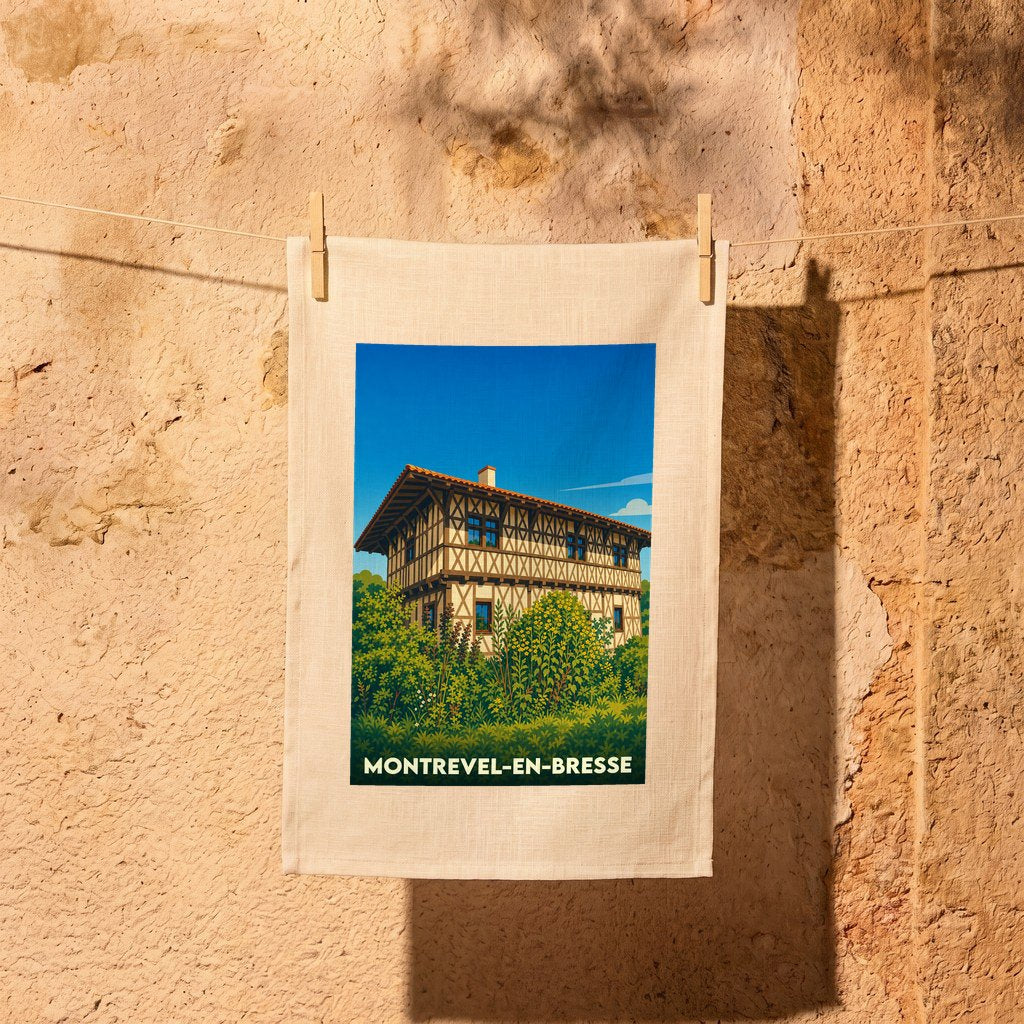 Torchon souvenir de la ville de Montrevel-en-Bresse avec une illustration stylisée d'une maison traditionnelle à colombages.