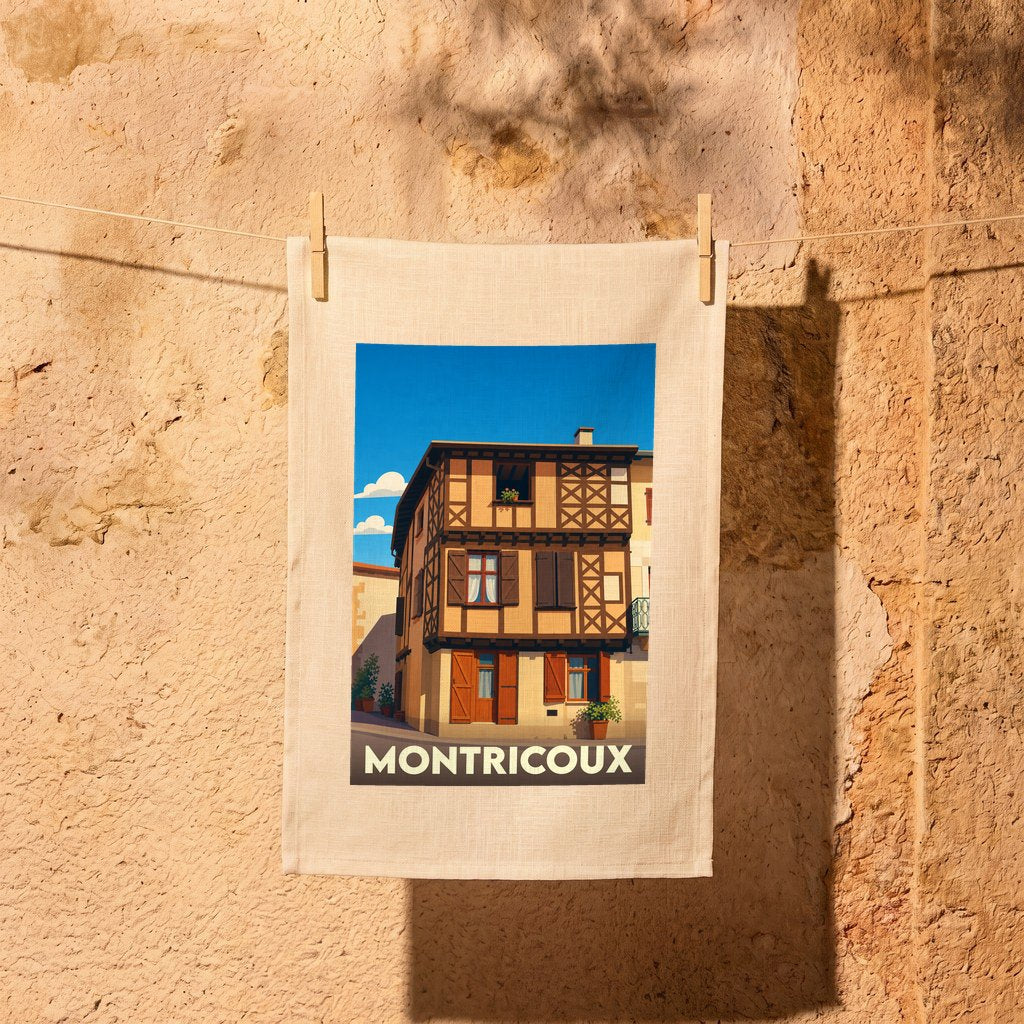 Torchon souvenir de la ville de Montricoux avec une illustration stylisée d'une maison à colombages.