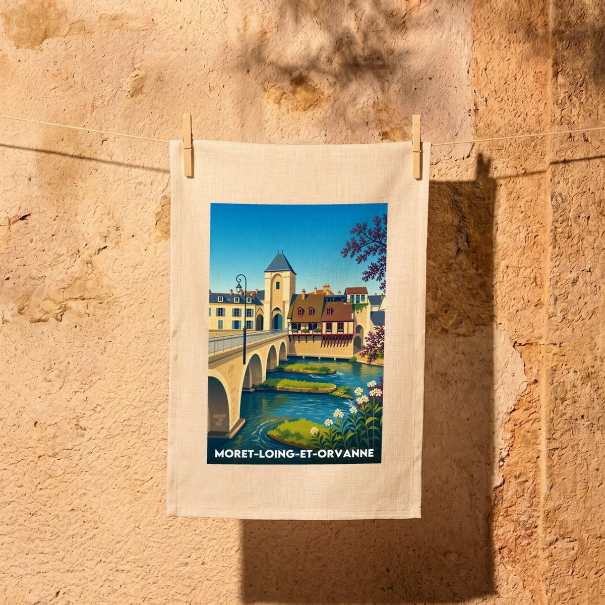 Torchon souvenir de Moret-Loing-et-Orvanne avec une illustration stylisée du vieux pont et de la rivière.