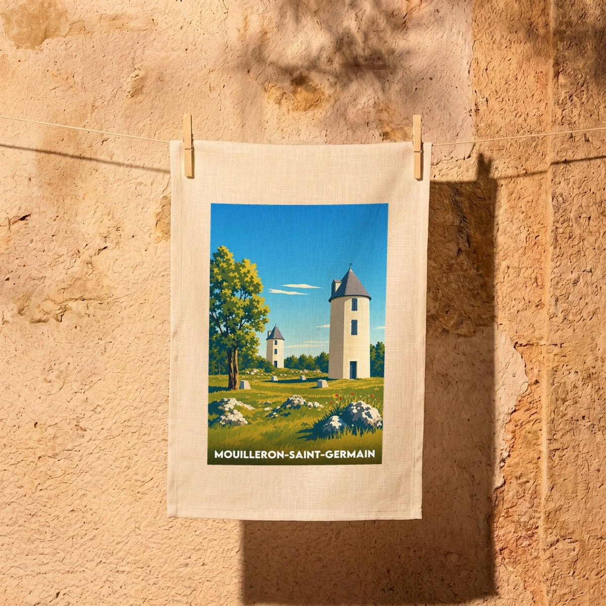 Torchon souvenir de la ville de Mouilleron-Saint-Germain avec une illustration stylisée représentant des tours dans un paysage champêtre.
