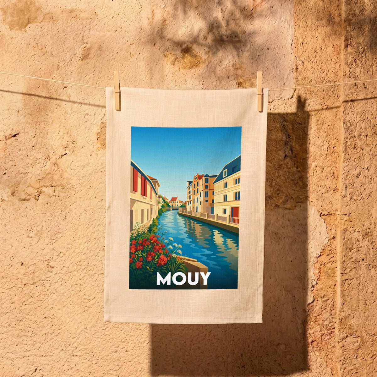 Torchon souvenir de la ville de Mouy avec une illustration stylisée d'un canal bordé de maisons.