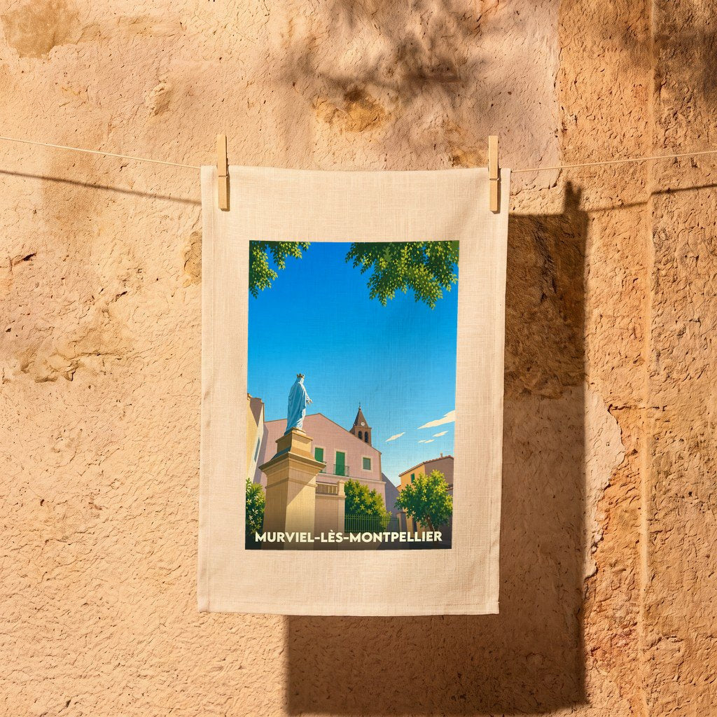 Torchon souvenir de Murviel-lès-Montpellier avec une illustration stylisée d'une statue et de l'église sous un ciel bleu.