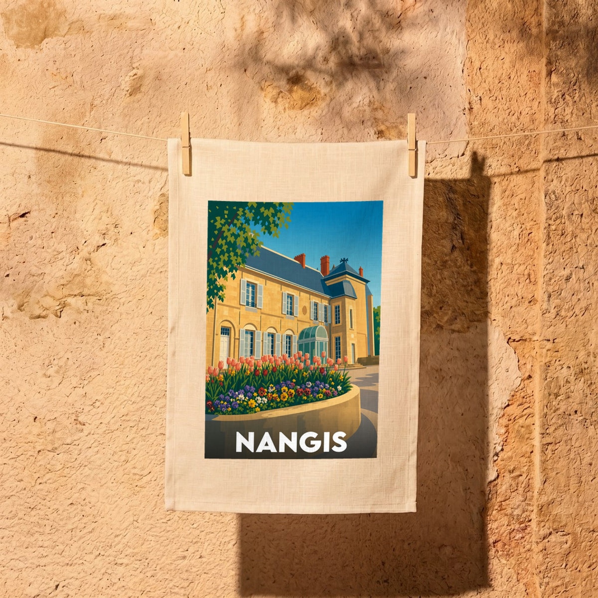 Torchon souvenir de la ville de Nangis avec une illustration stylisée d'un bâtiment historique et d'un parterre de fleurs.