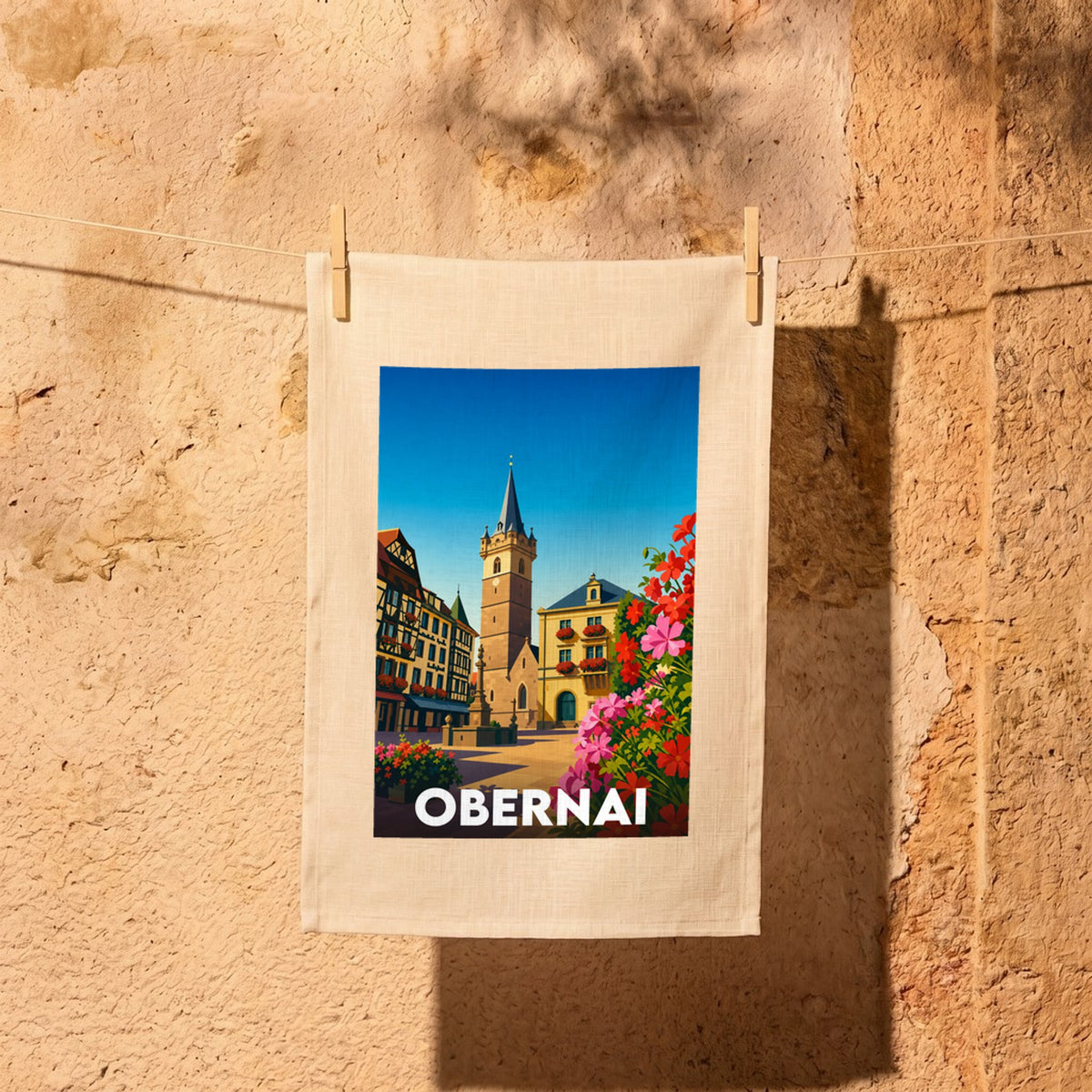 Torchon souvenir de la ville d'Obernai avec une illustration stylisée de son architecture traditionnelle.