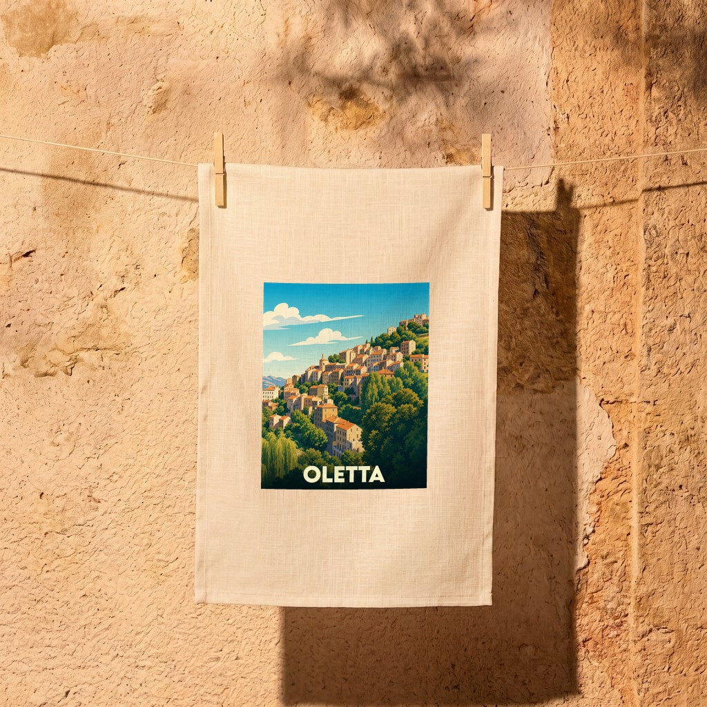 Torchon souvenir de la ville d'Oletta orné d'une illustration stylisée d'un village corse perché.