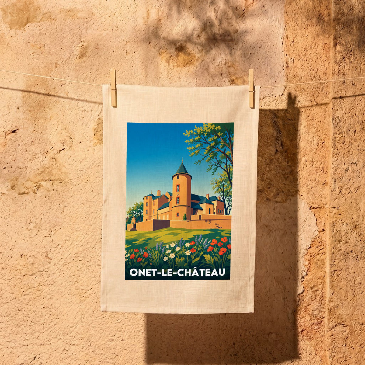 Torchon souvenir de la ville d'Onet-le-Château avec une illustration stylisée de son château médiéval.