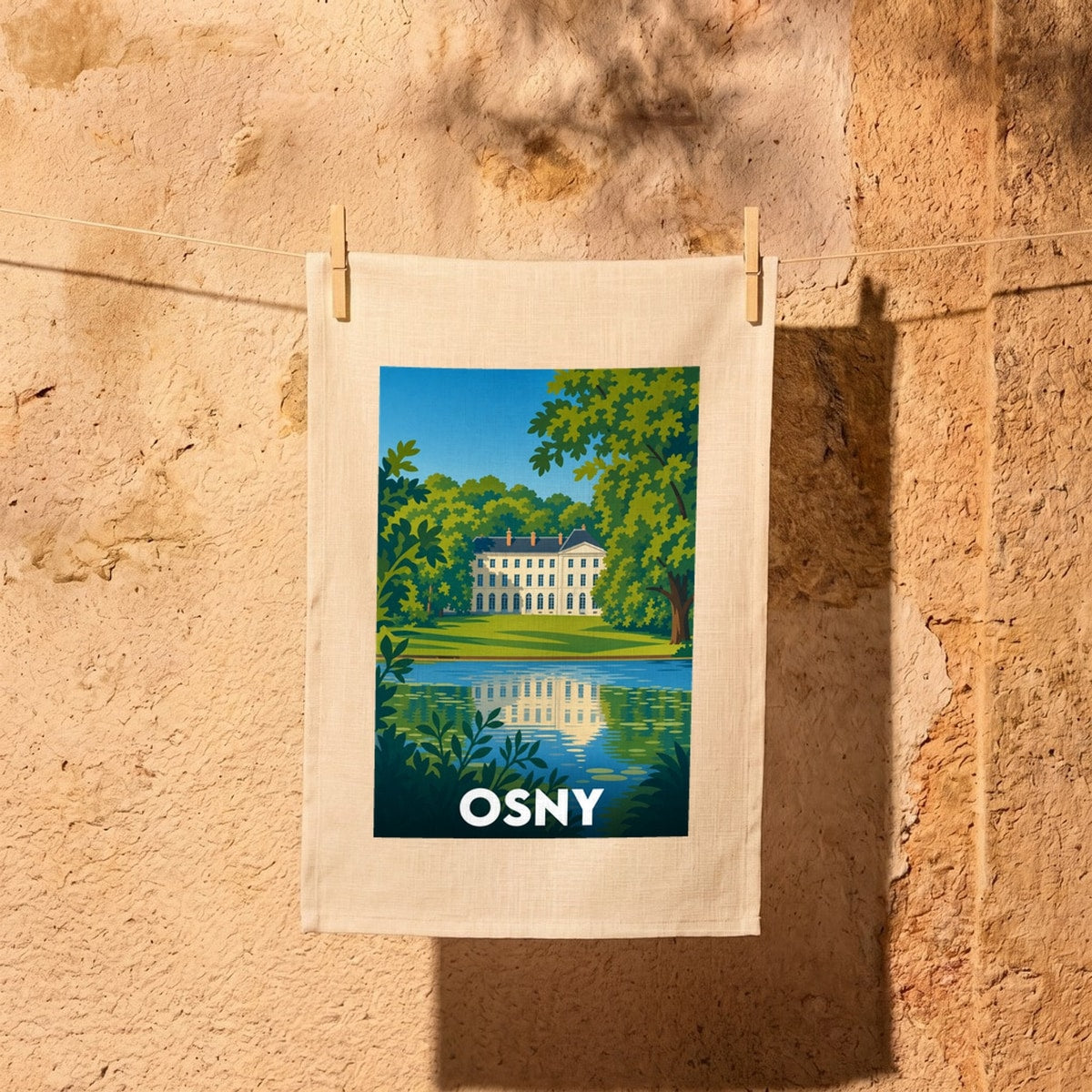 Torchon souvenir de la ville d'Osny avec une illustration stylisée de son château au bord de l'eau.