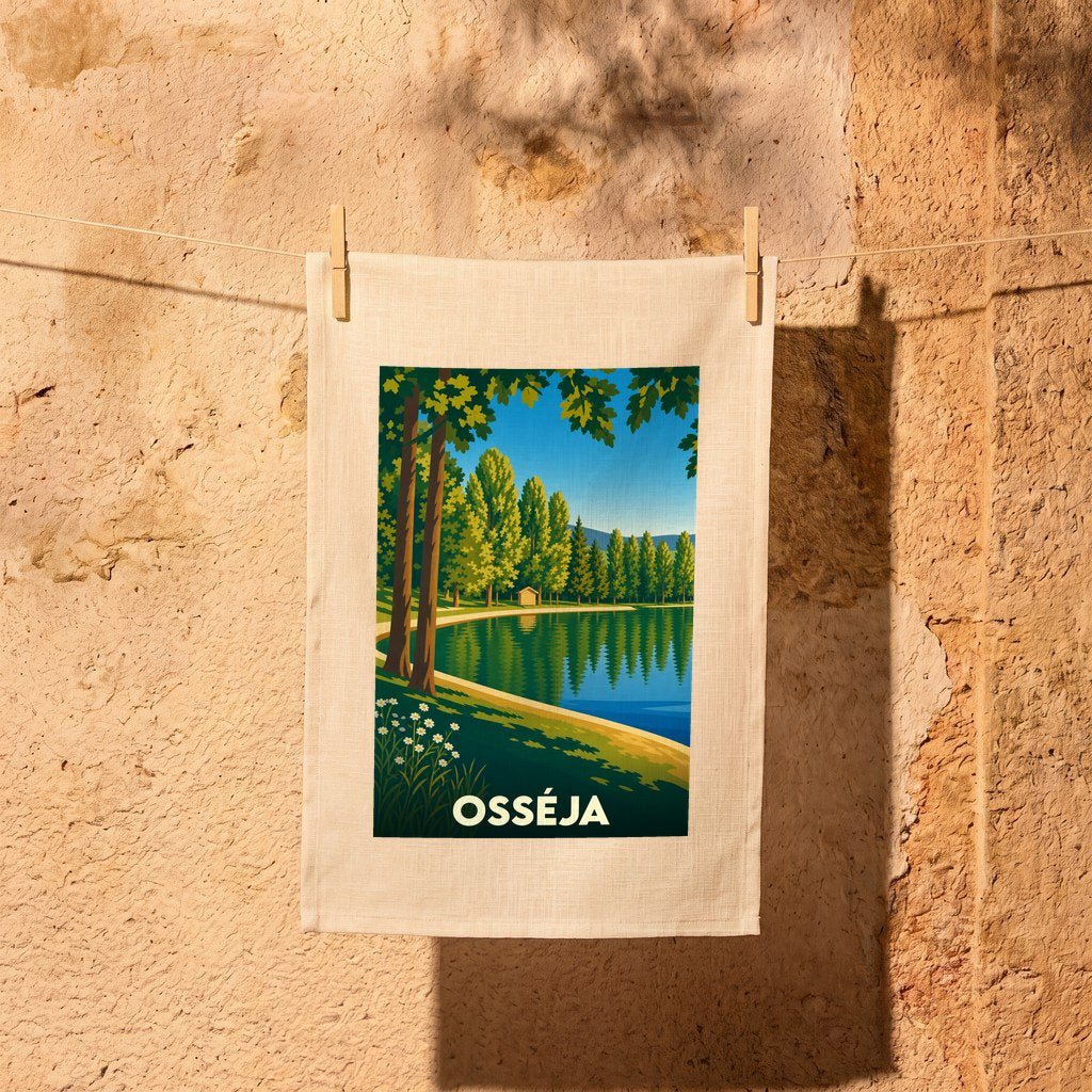 Torchon souvenir de la ville d'Osséja avec une illustration stylisée d'un lac bordé d'arbres.