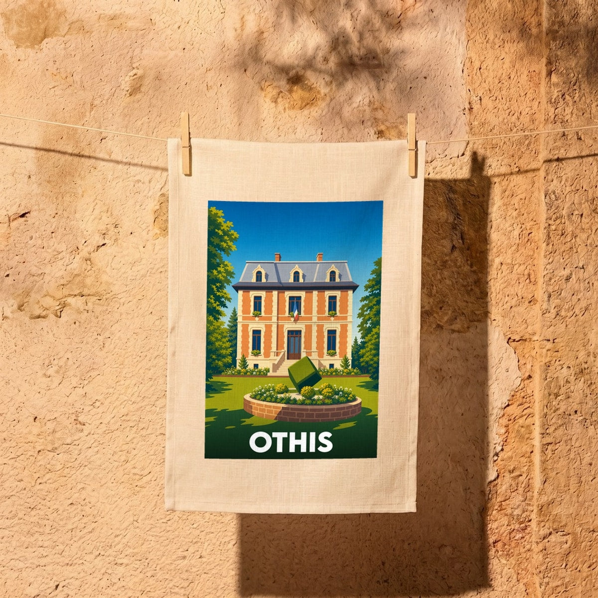 Torchon souvenir de la ville d'Othis avec une illustration stylisée d'une demeure de caractère.