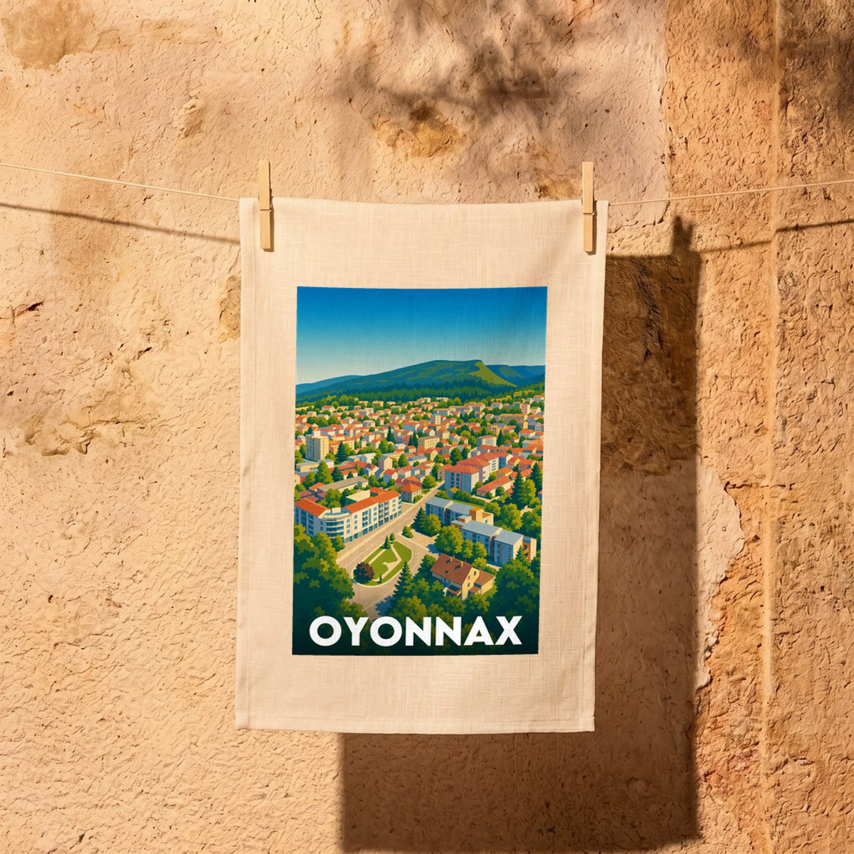 Torchon souvenir de la ville d'Oyonnax illustré d'une vue panoramique stylisée et colorée.