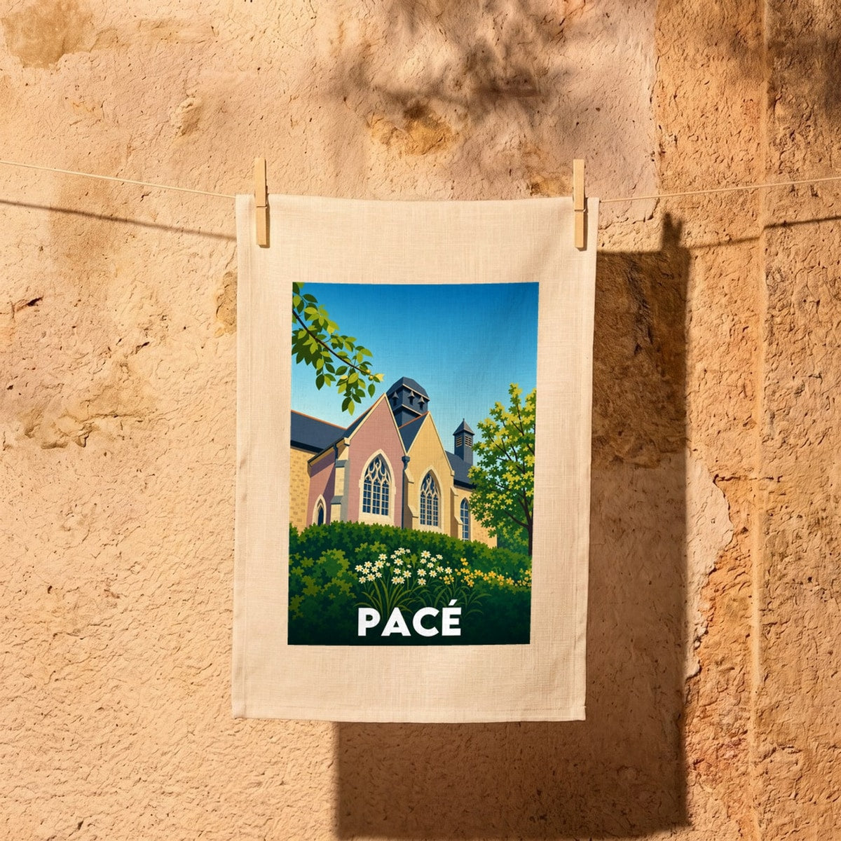 Torchon souvenir de la ville de Pacé avec une illustration graphique et colorée de son église.