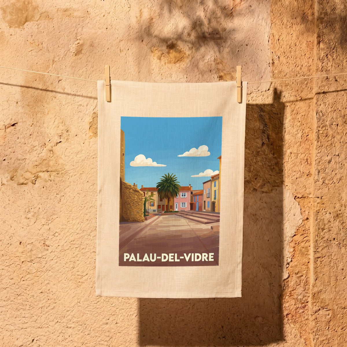 Torchon souvenir de la ville de Palau-del-Vidre avec une illustration stylisée.