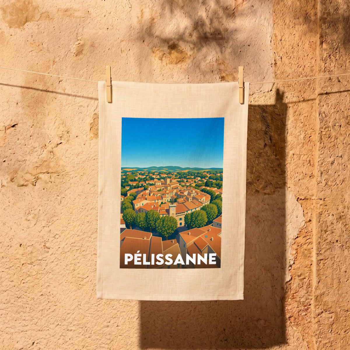 Torchon souvenir de la ville de Pélissanne avec une illustration stylisée d'un village provençal.