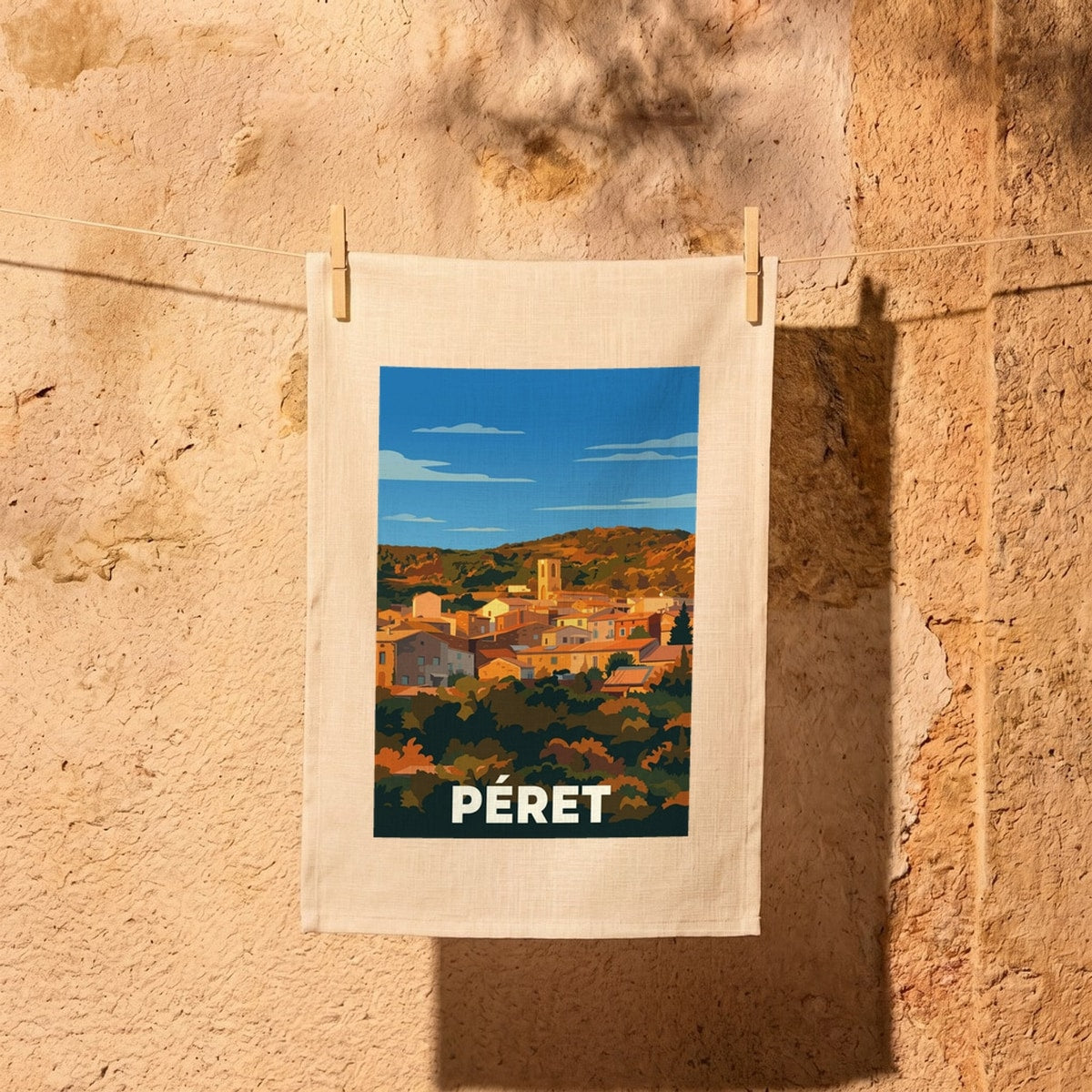 Torchon souvenir de la ville de Péret avec une illustration stylisée du village.