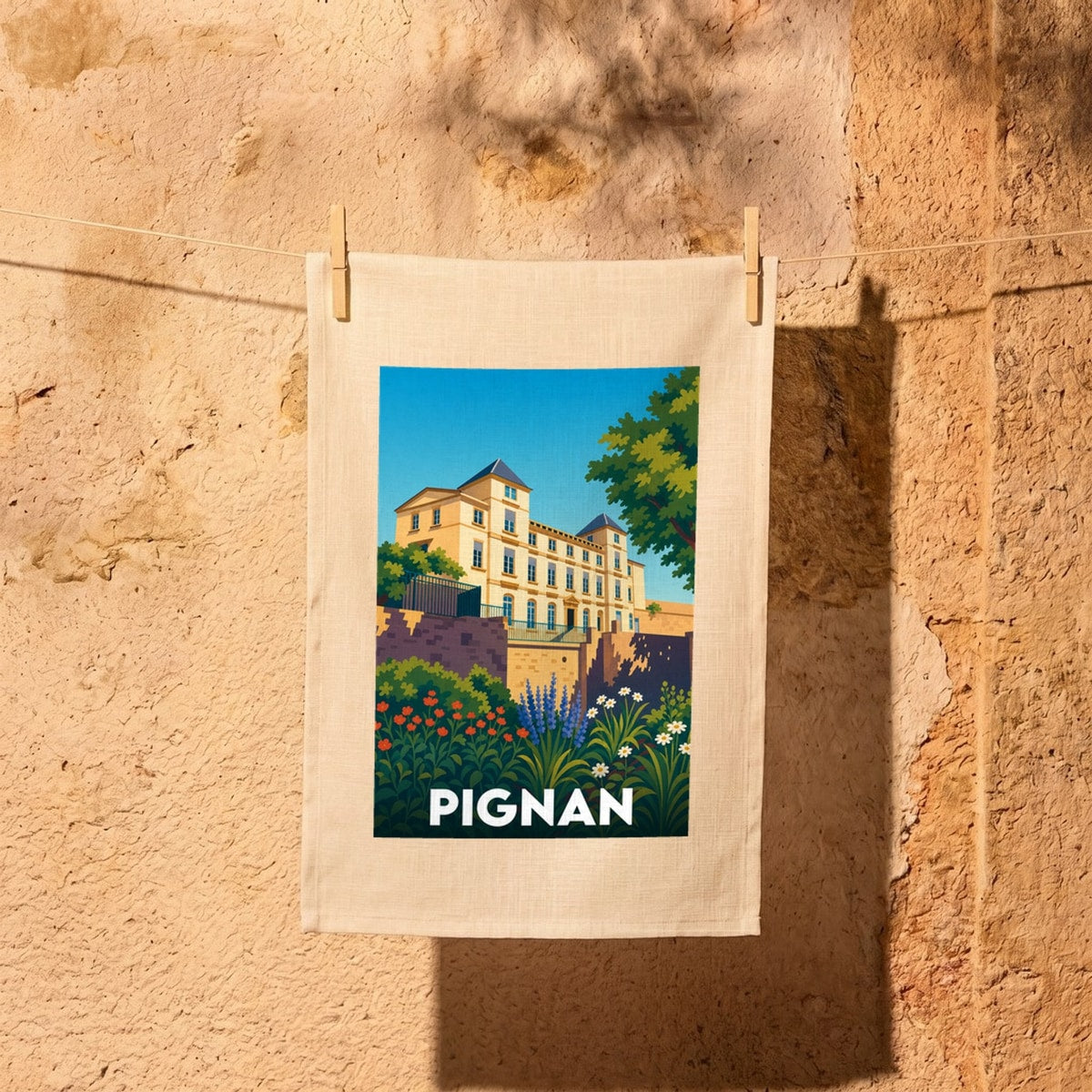 Torchon souvenir de la ville de Pignan illustré d'un château majestueux et de jardins fleuris.