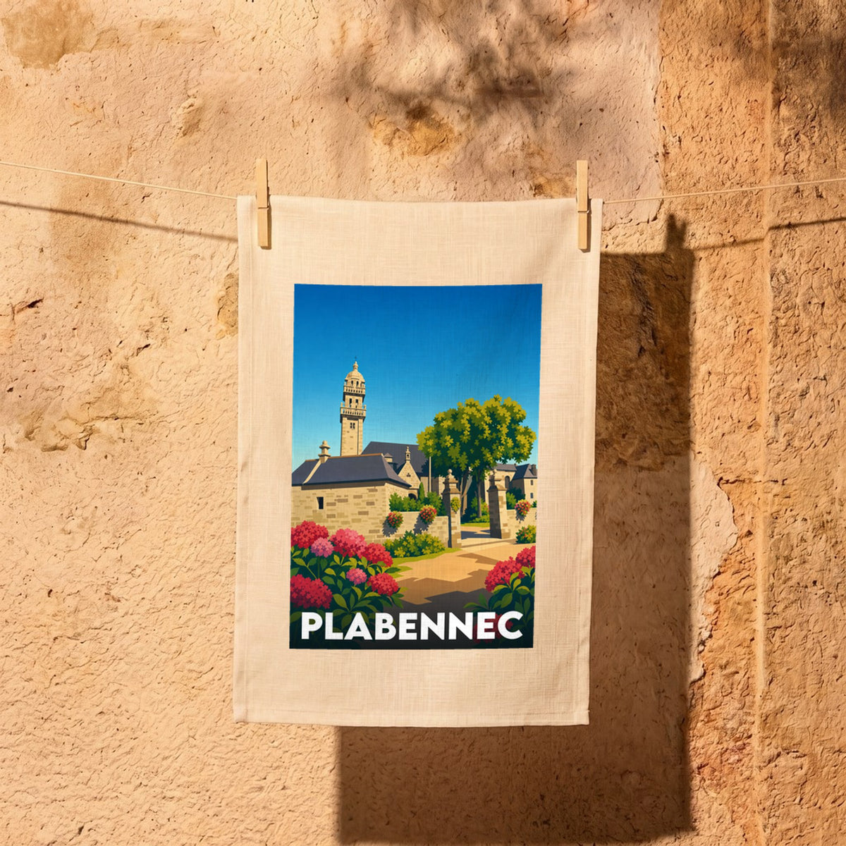 Torchon souvenir de la ville de Plabennec illustré d'un paysage stylisé de son église et de fleurs colorées.