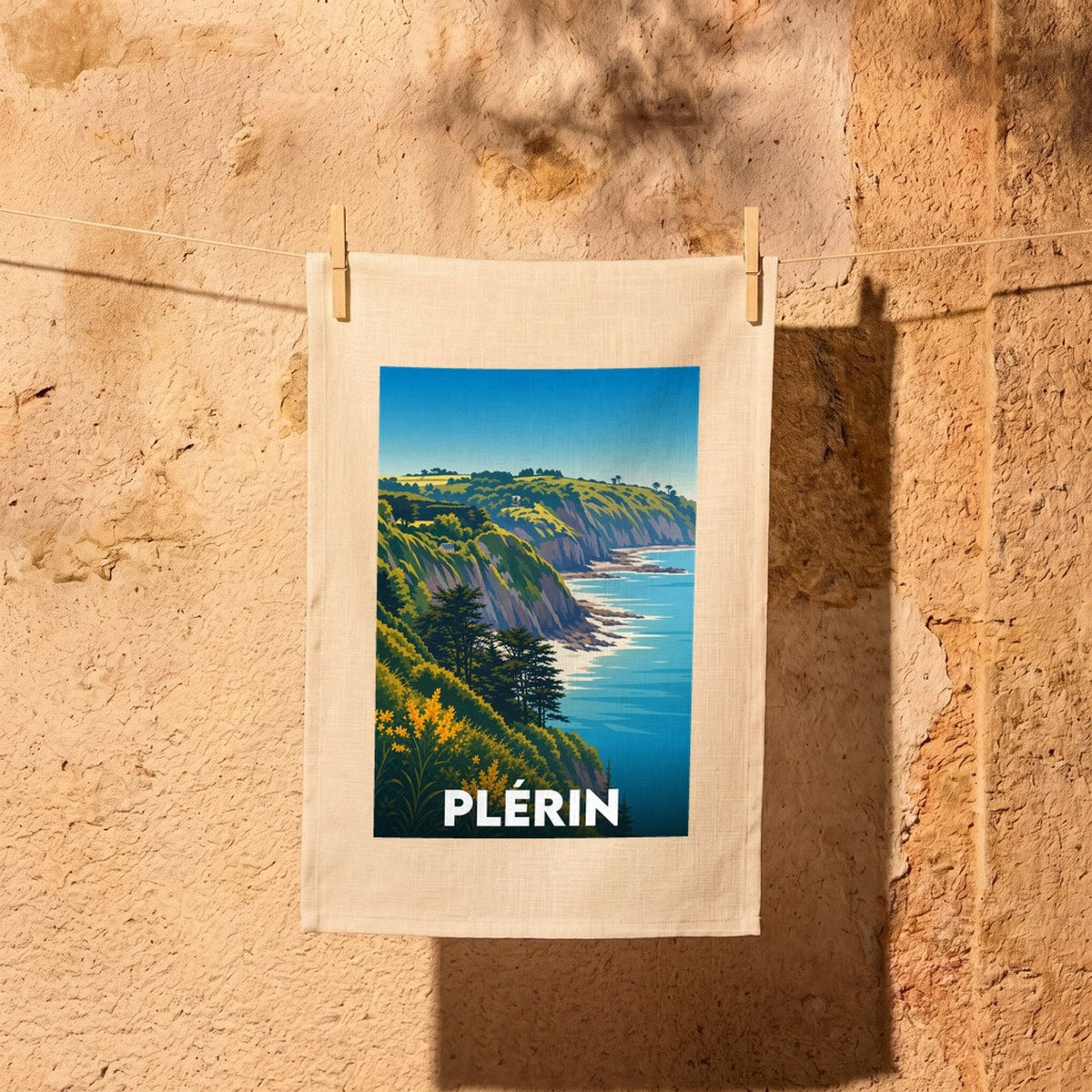 Torchon souvenir de la ville de Plérin avec une illustration stylisée de falaises côtières.