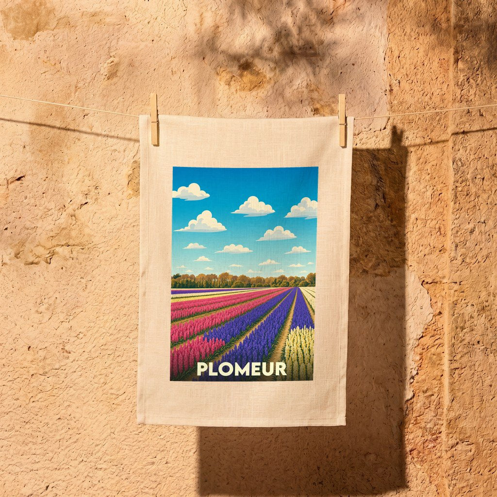Torchon souvenir de la ville de Plomeur illustré par un champ de fleurs coloré sous un ciel bleu.